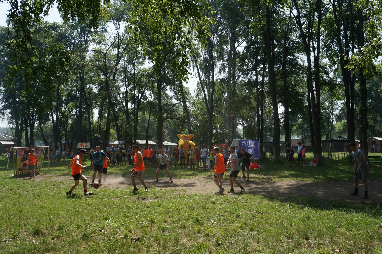 Мужчины играют в футбол в лесу